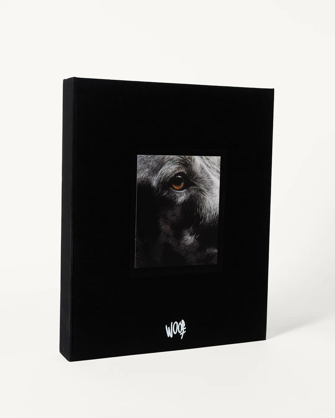 La caja de lino negro de WOOF, con el retrato de un perro asomando en su ventana